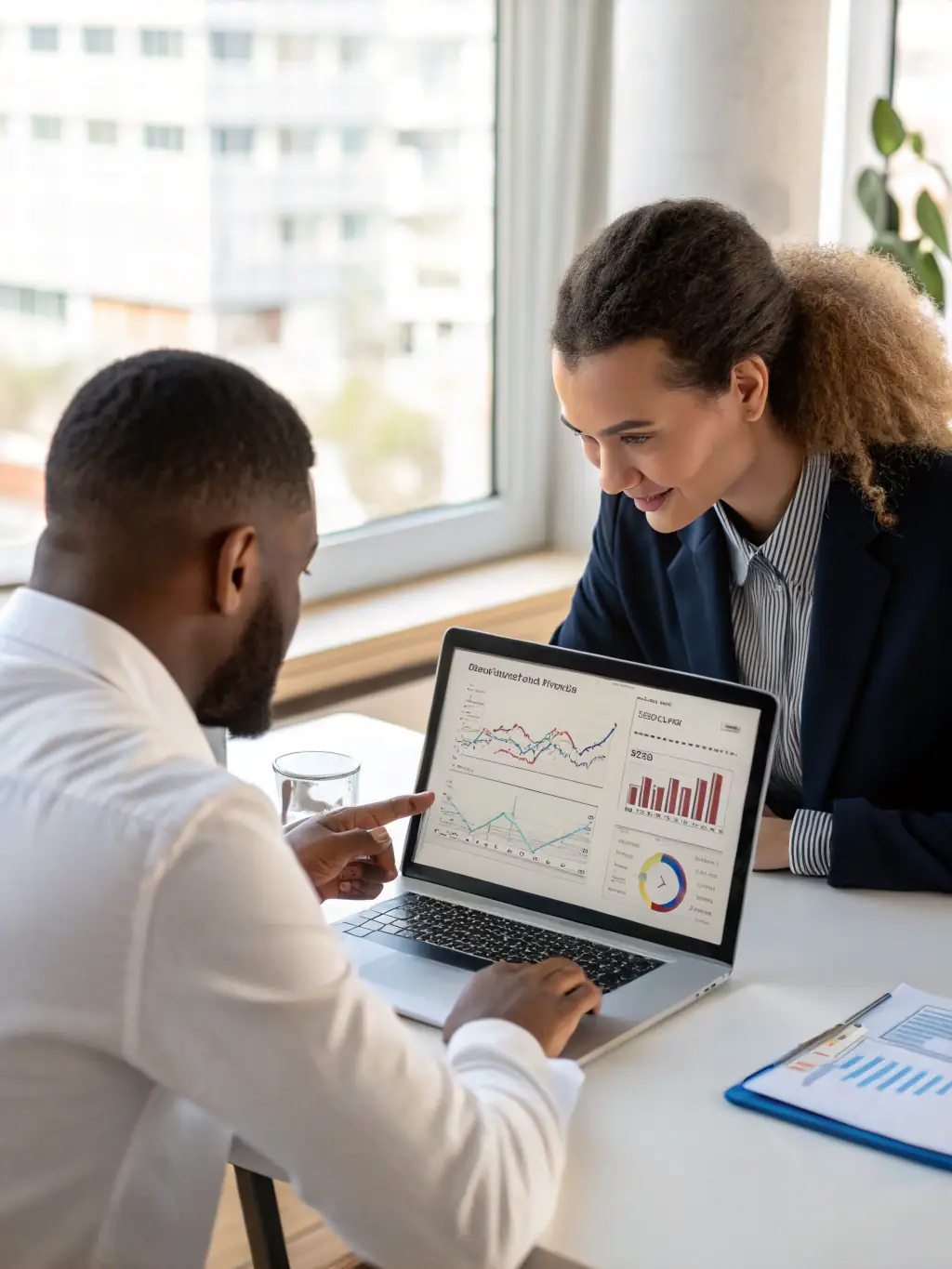 A professional photograph of a financial coach sitting across a table from an entrepreneur, reviewing financial documents and discussing investment strategies, symbolizing the personalized guidance offered in the 'Startup Success' package.